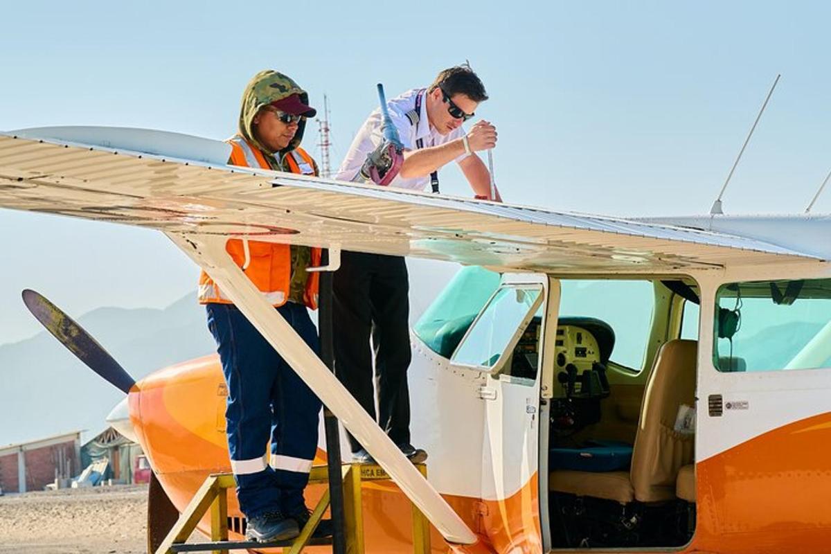 two people standing on the wing of an airplane