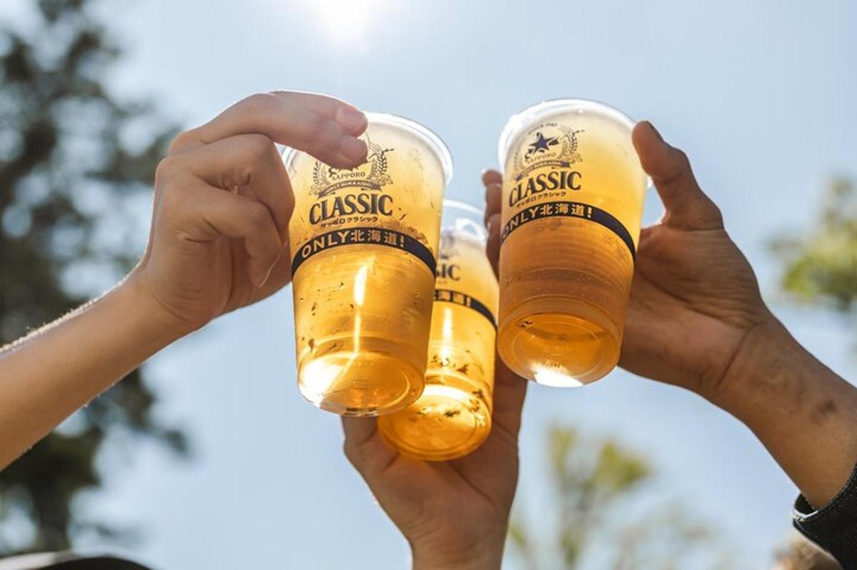 two people holding up two glasses of beer