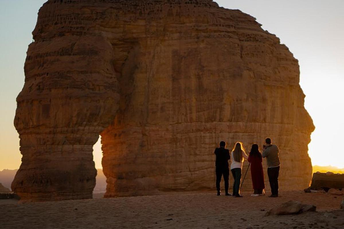 a group of people standing in front of a rock formation