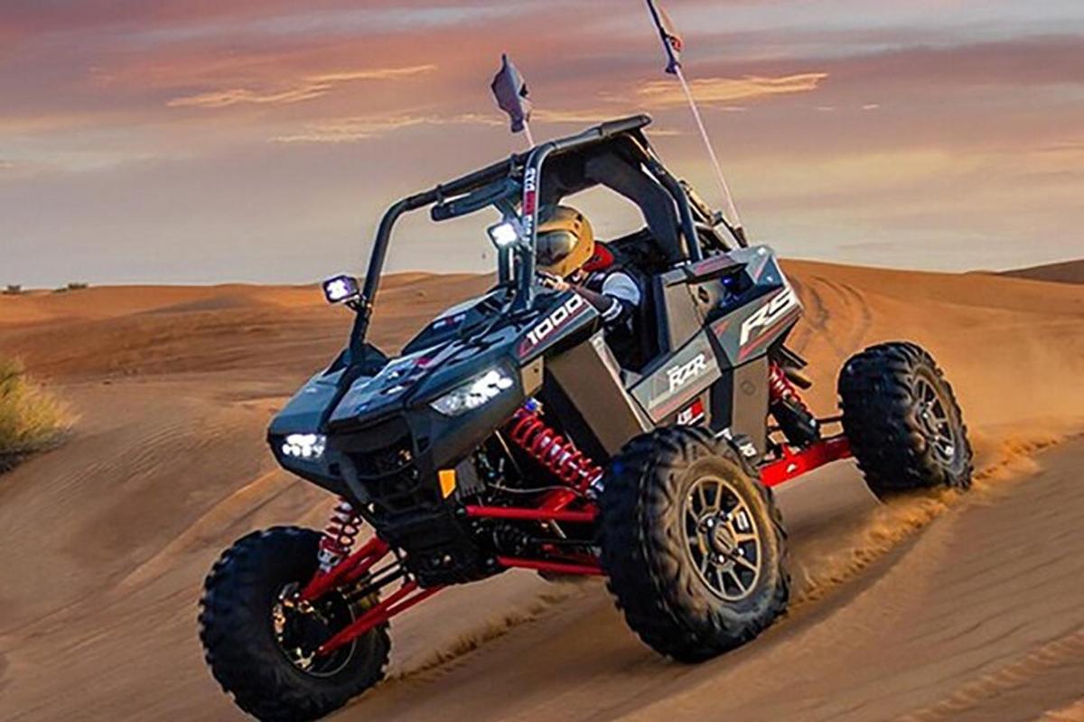 osoba jedoucí na čtyřkolce v poušti