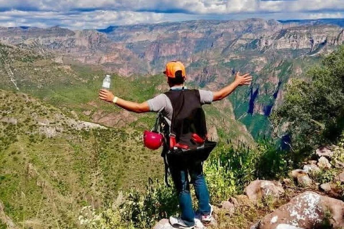 一名男子站在山顶，张开双臂