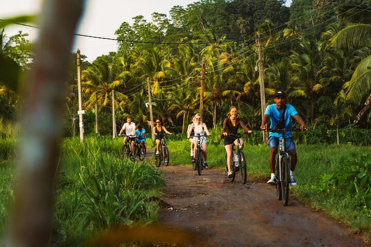 a group of people riding bikes down a dirt road