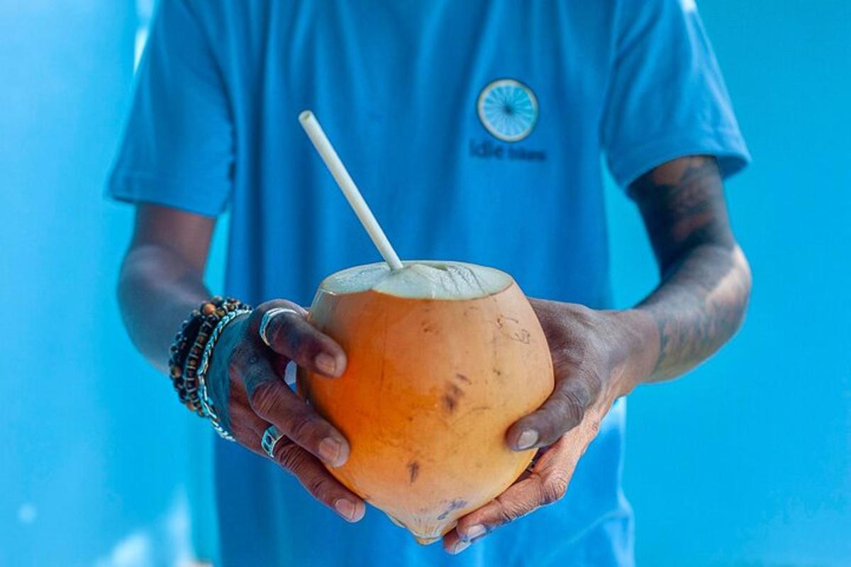 a man holding a coconut with a straw in it