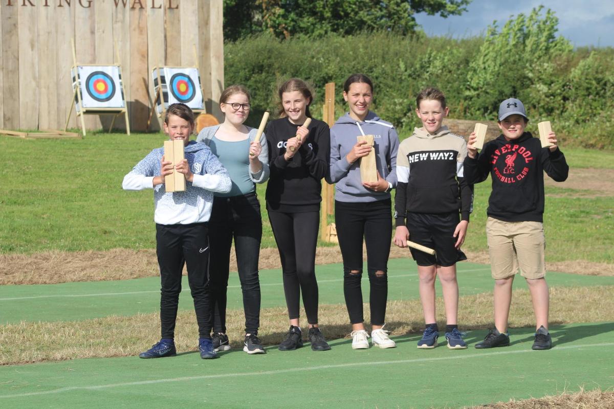 a group of people holding up wooden targets