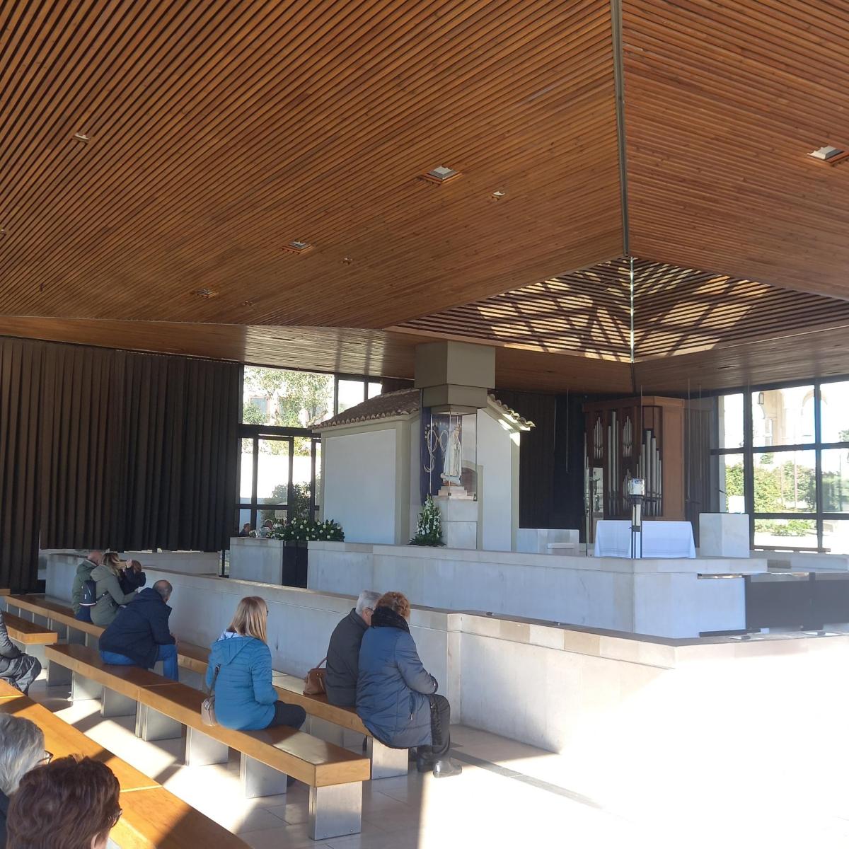 a group of people sitting on benches in a building