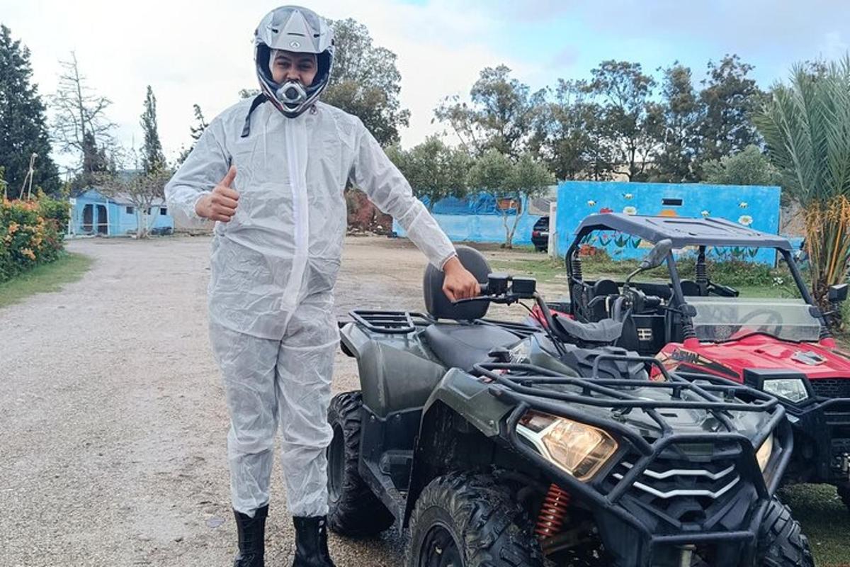 Muž stojí vedle čtyřkolky a ukazuje palec nahoru