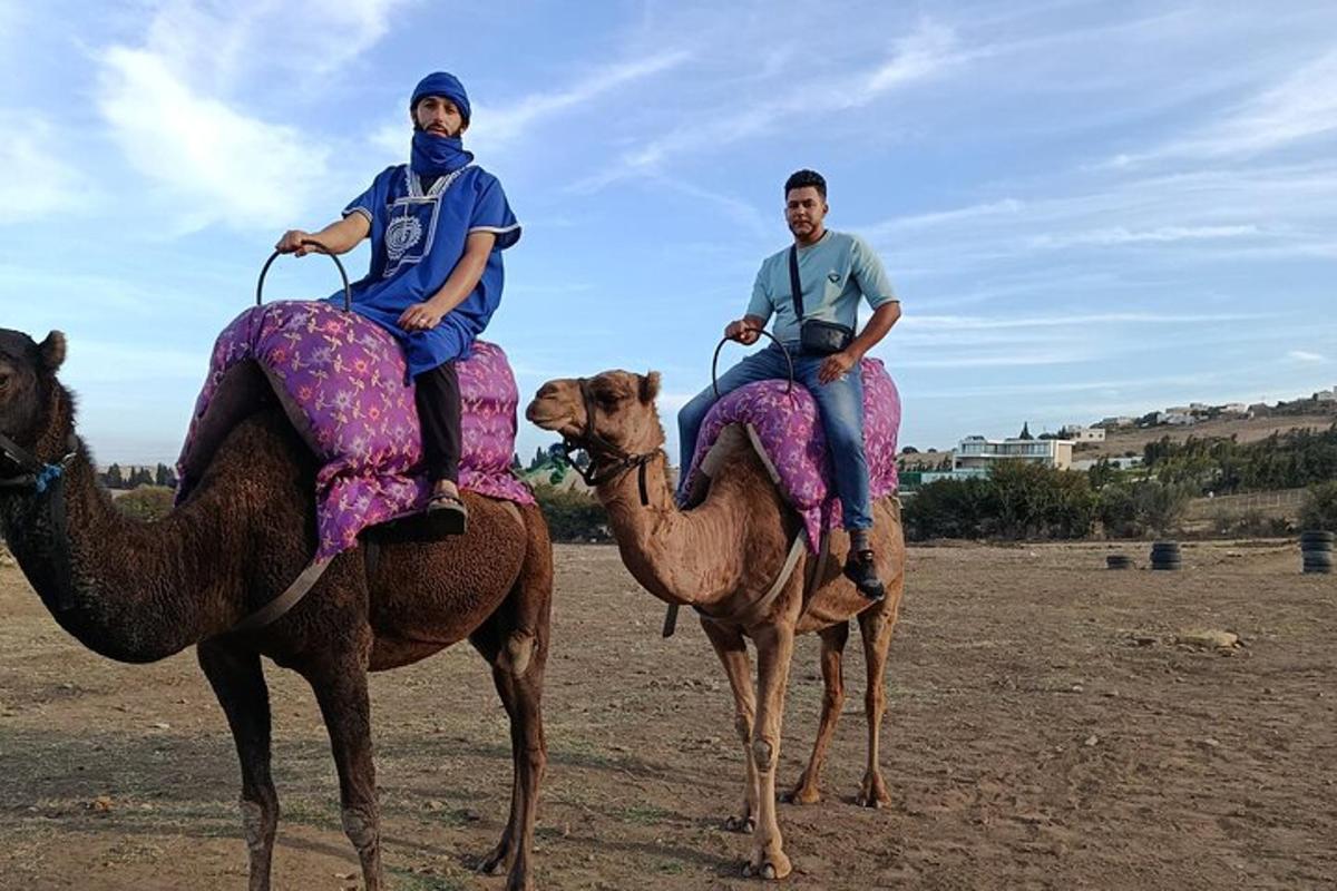 dva muži jedou na hřbetech velbloudů