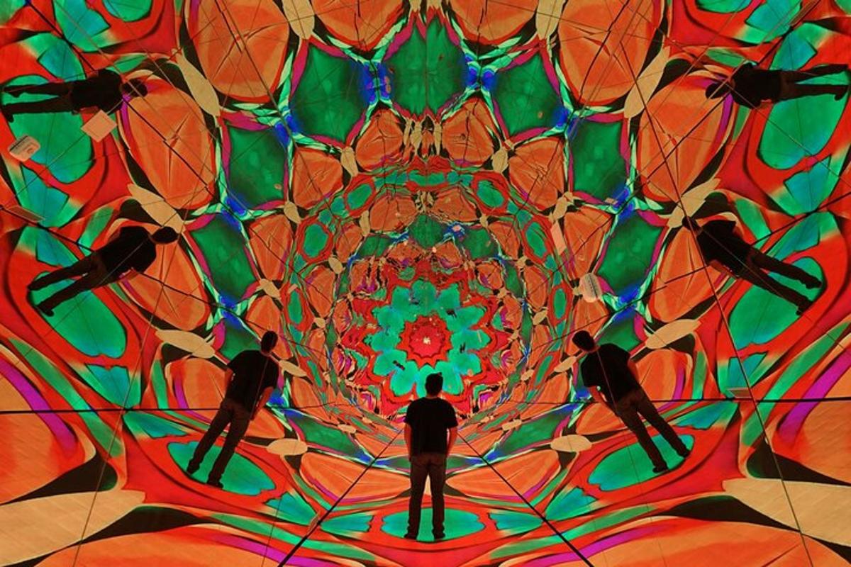 a group of people standing in front of a mandala