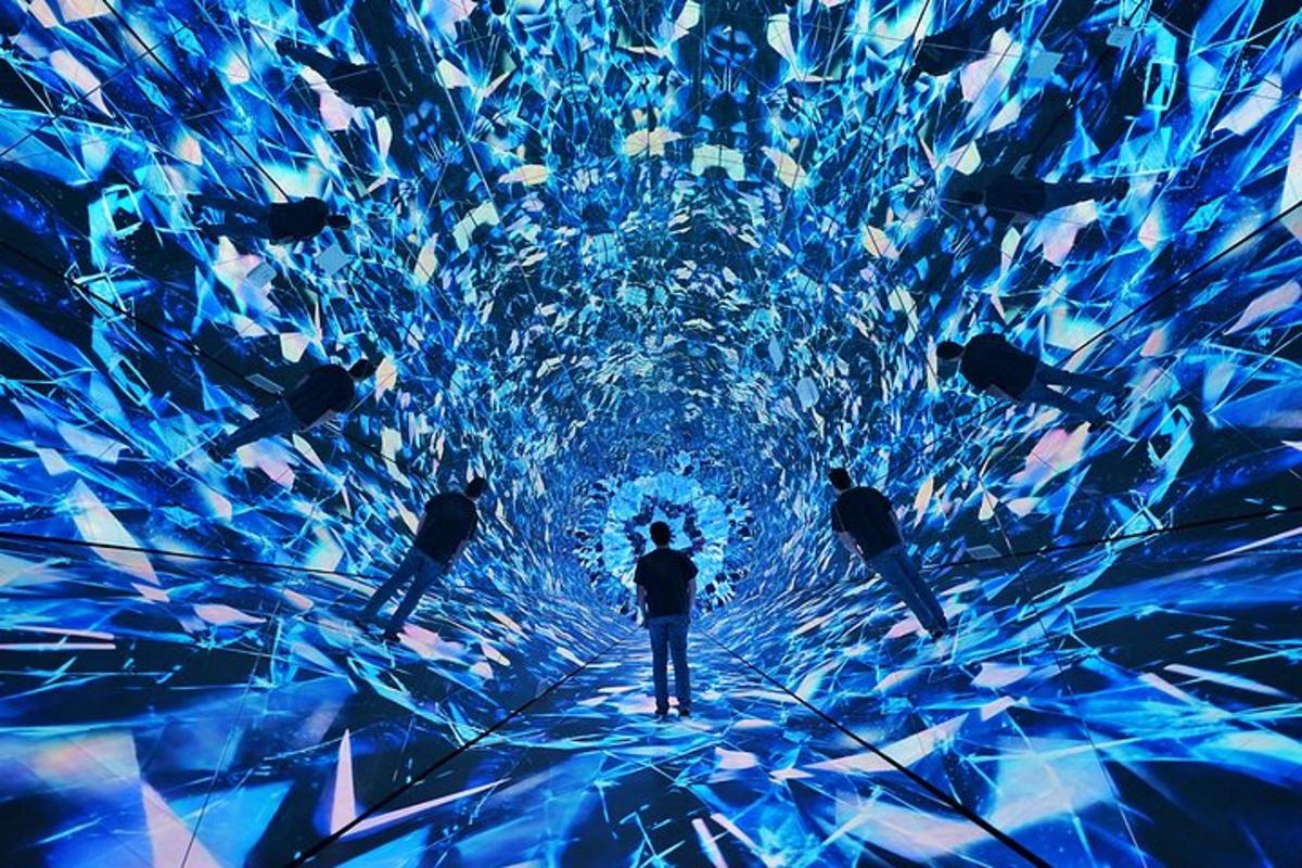 a group of people standing in front of a tunnel of fish