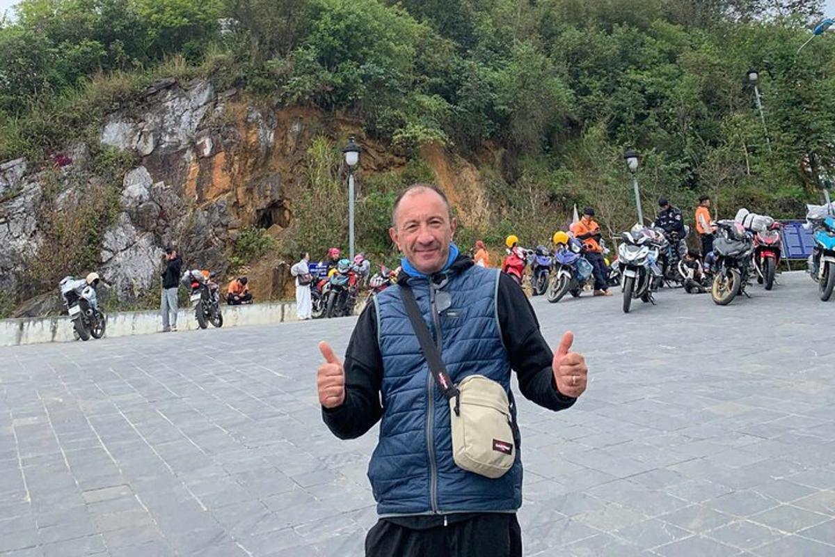 一名男子在一群摩托车前竖起大拇指