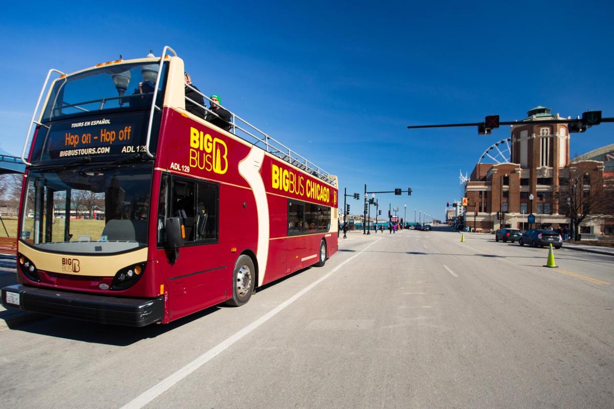 a red double decker bus driving down a street
