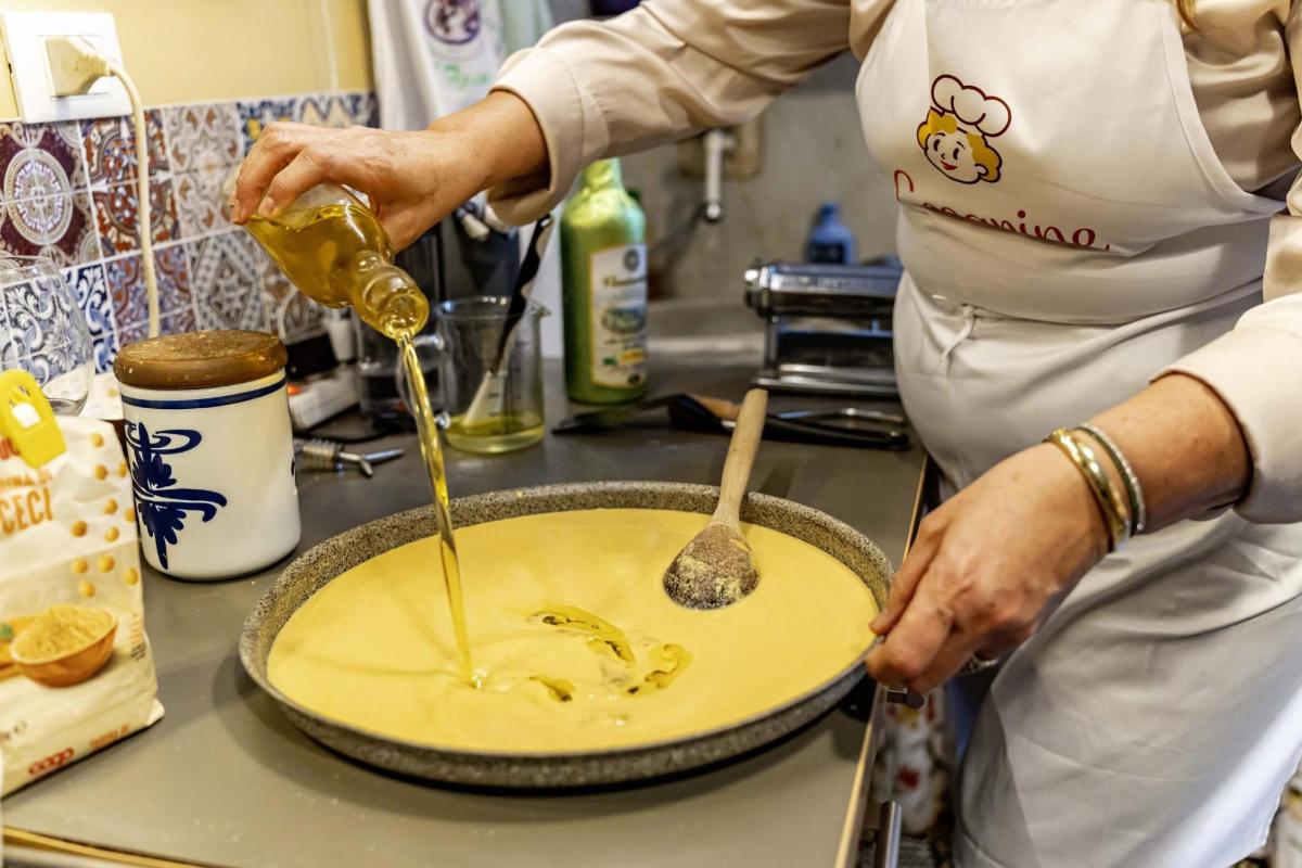 člověk nalévá hořčici do koláče