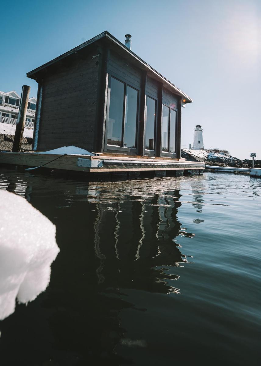 a small house on a dock on a body of water