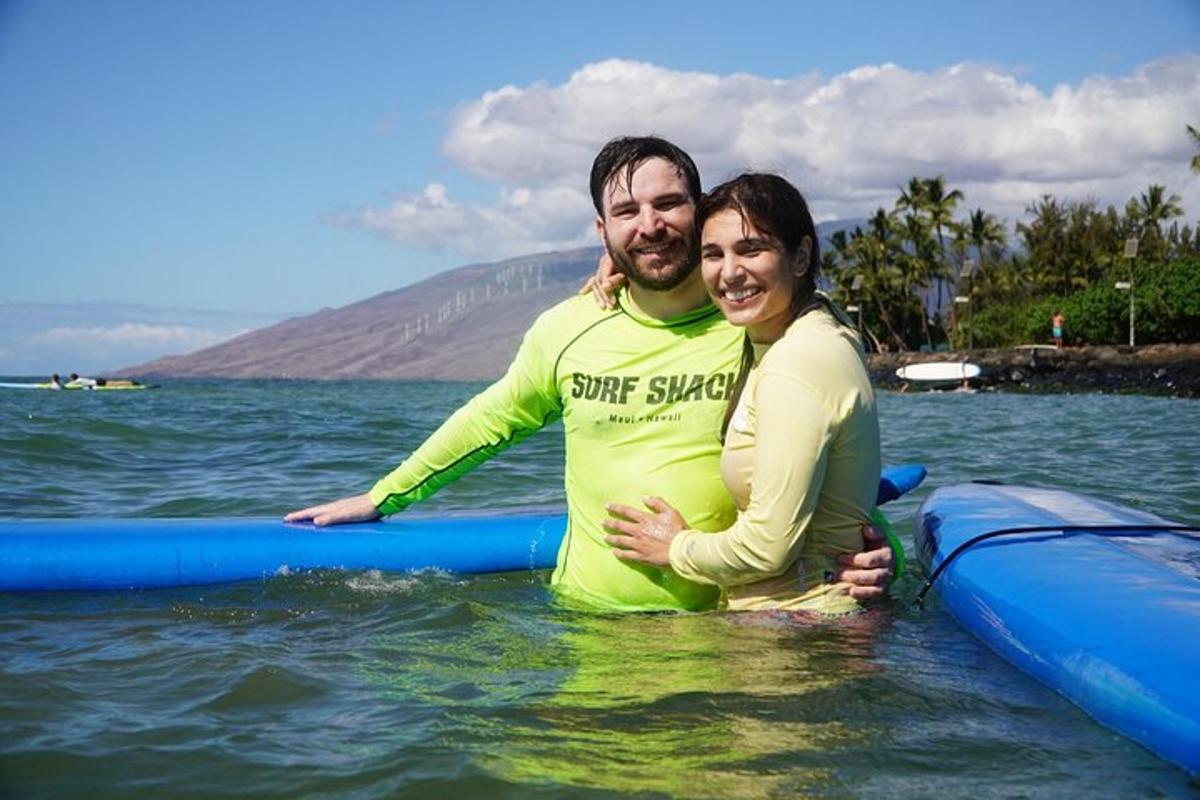 a man and woman standing on surfboards in the water
