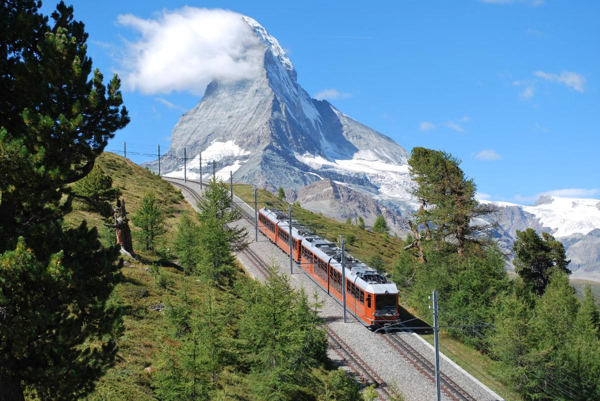 a train traveling past a snow covered mountain