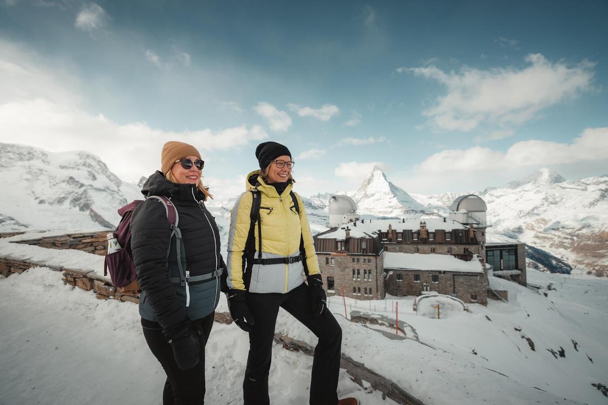 两名妇女站在白雪皑皑的山顶上