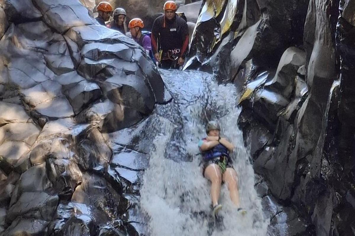 一名女子坐在人造瀑布上。