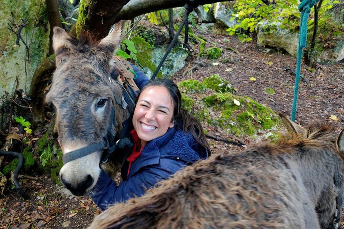 Žena se usmívá vedle osla