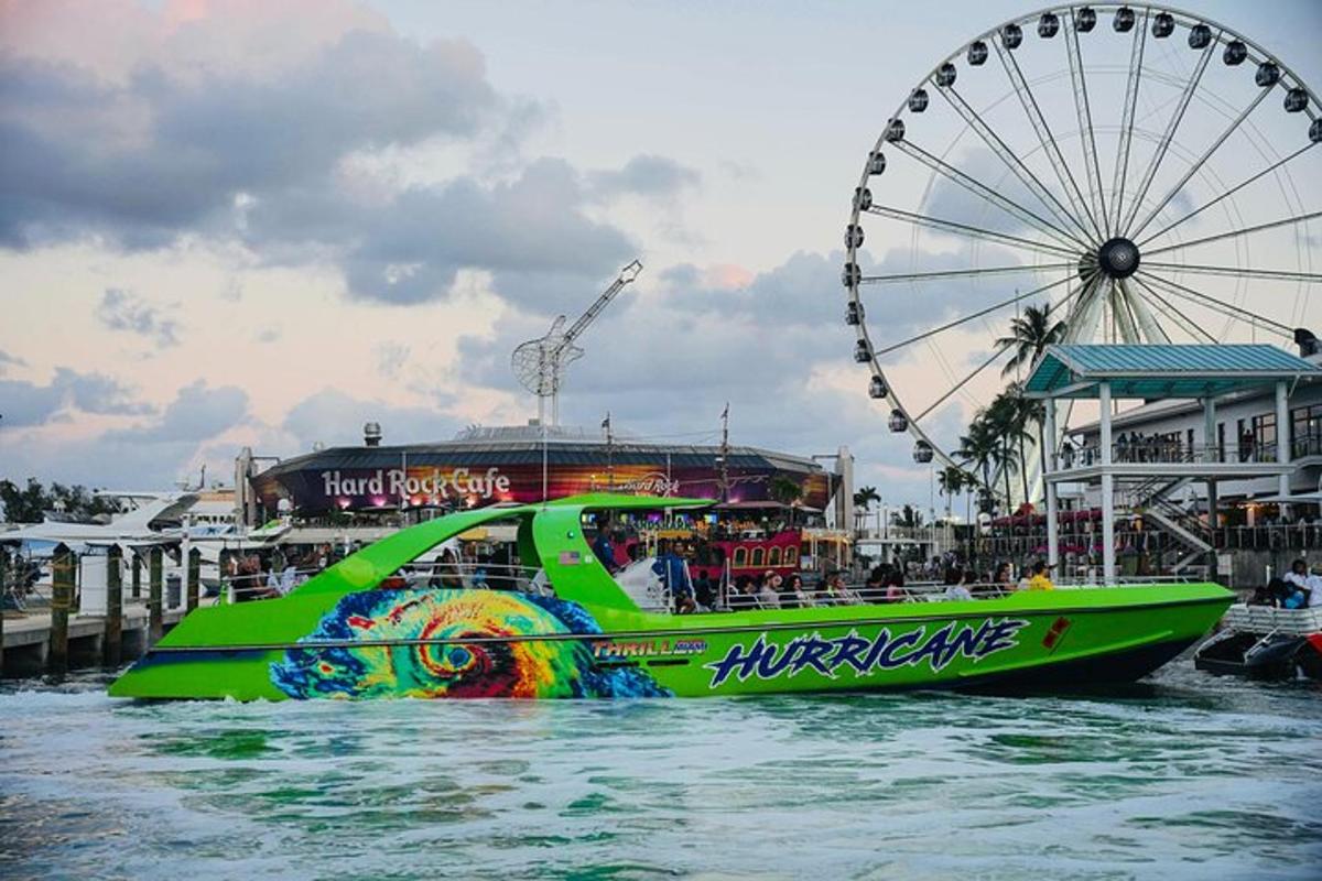 a green boat in the water next to a ferris wheel