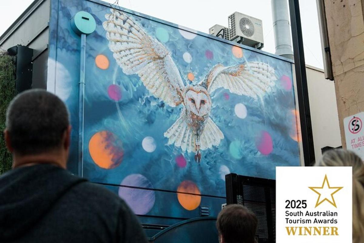 a man standing in front of a screen with a painting of an owl