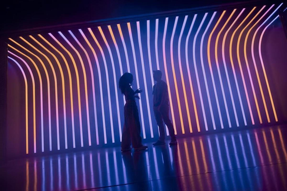 two people standing in front of a colorful wall