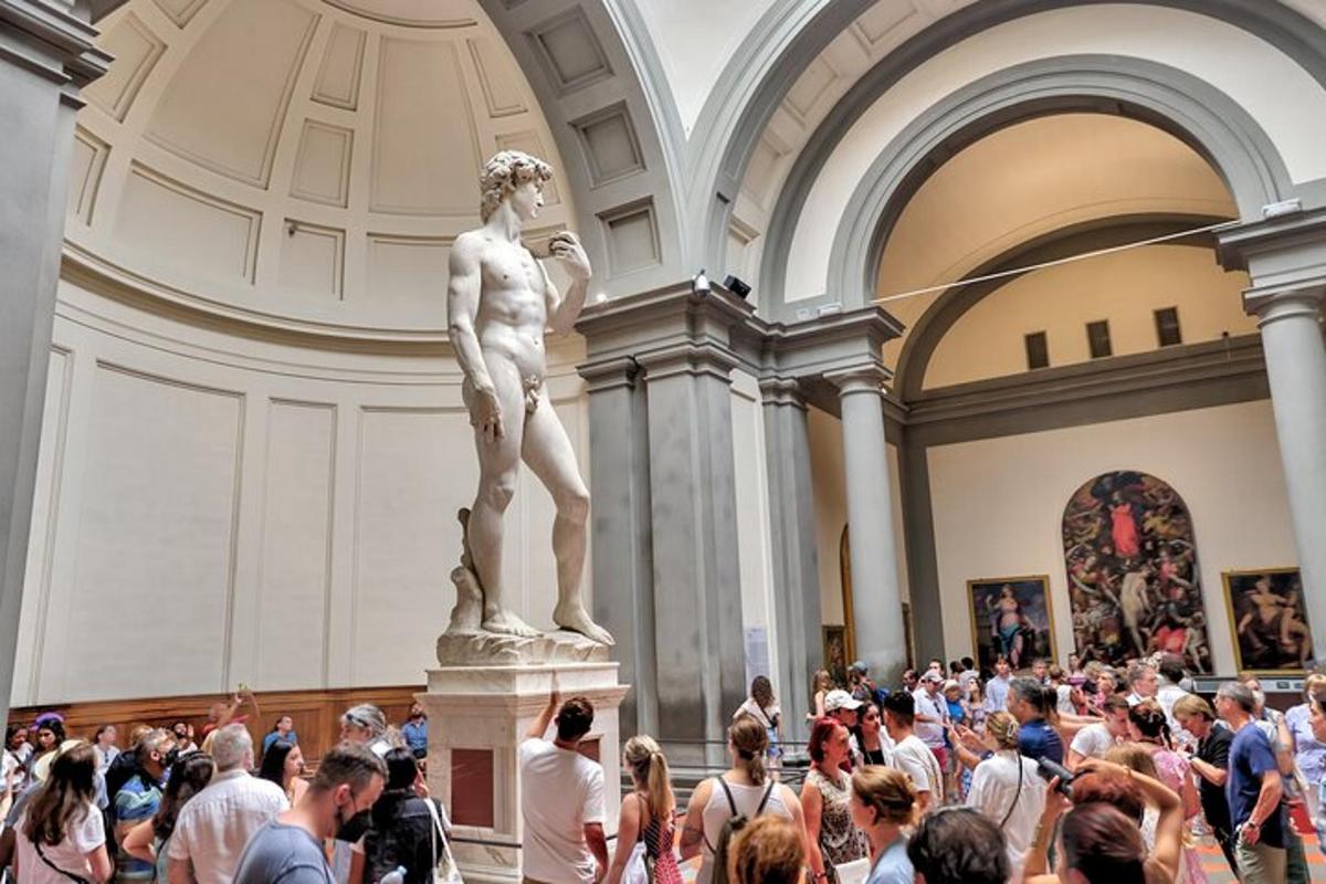 a crowd of people standing around a statue in a museum