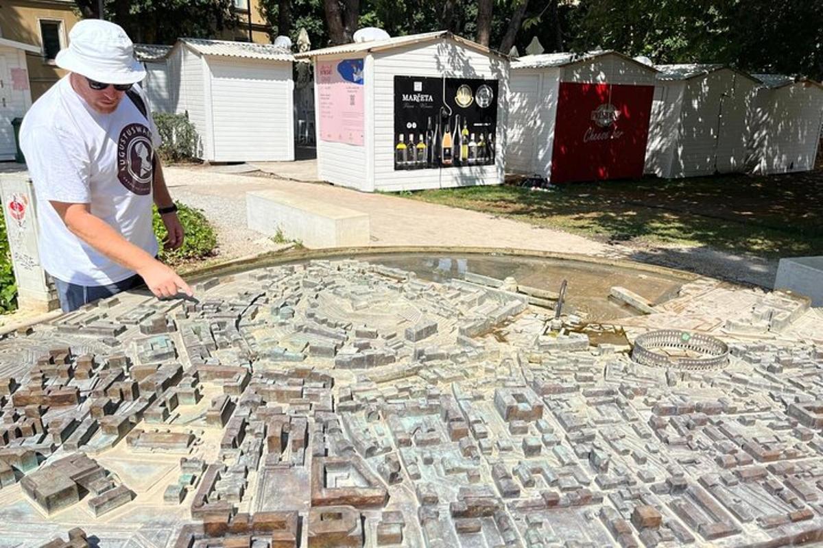 a man standing next to a large mosaic of rocks