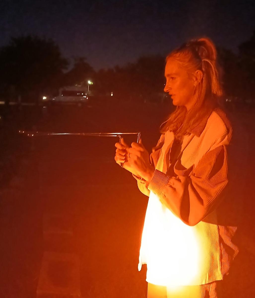 a woman is holding a gun at night
