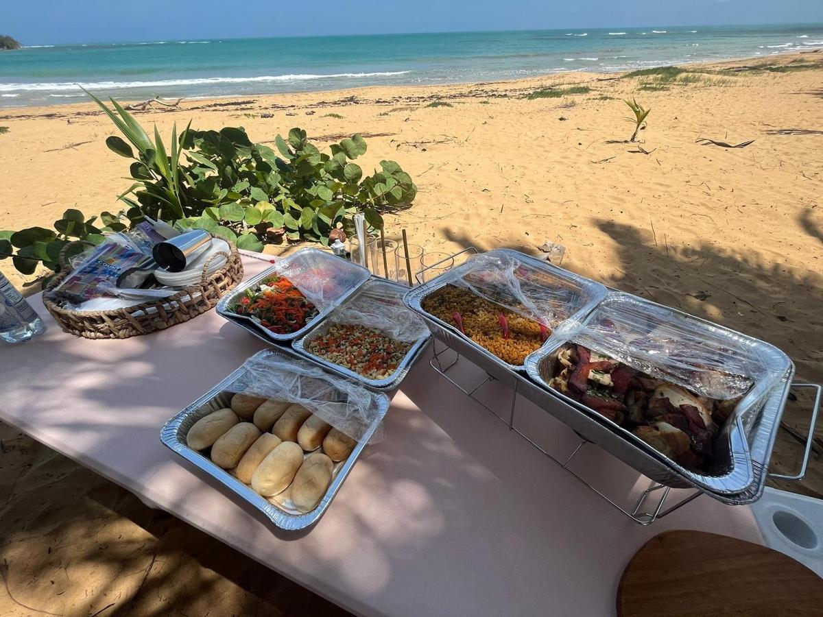 a table with several containers of food on the beach