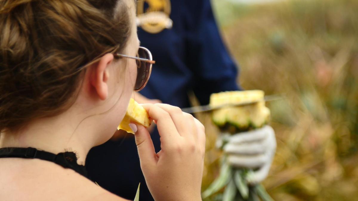 a woman with glasses eating a piece of food