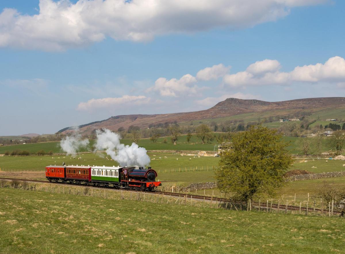 a steam train traveling down the tracks in a field