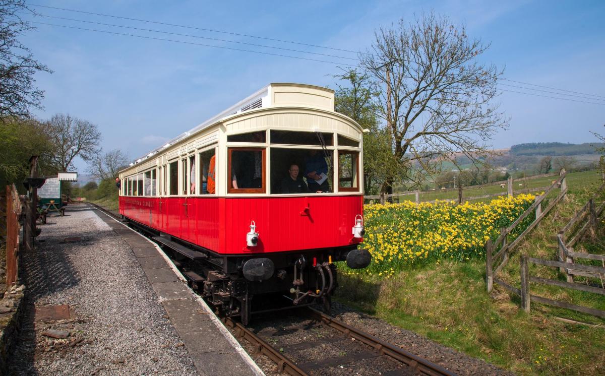 a red and white train traveling down the tracks