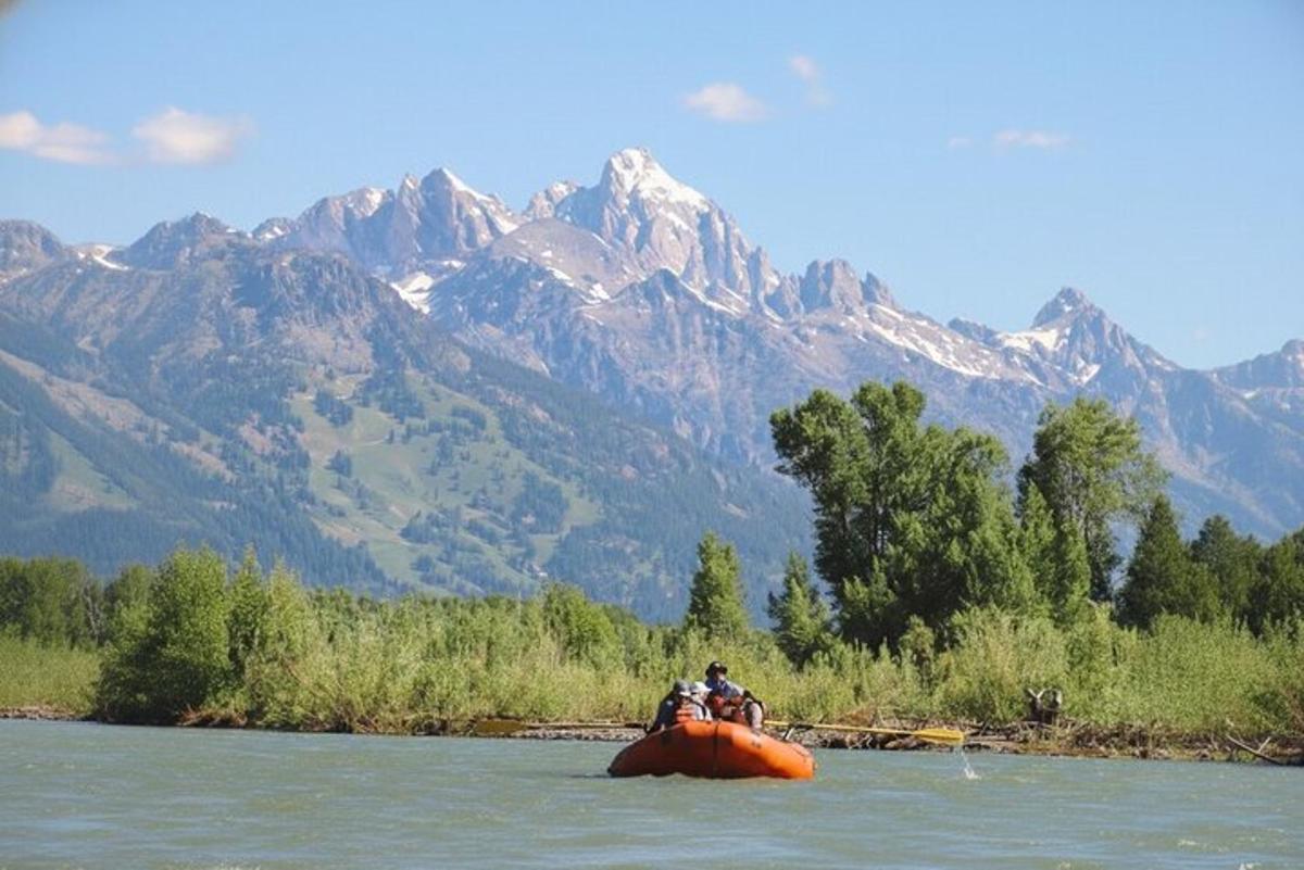 a group of people riding on an orange raft in the water