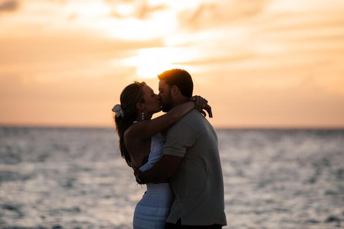 a man and a woman kissing on the beach