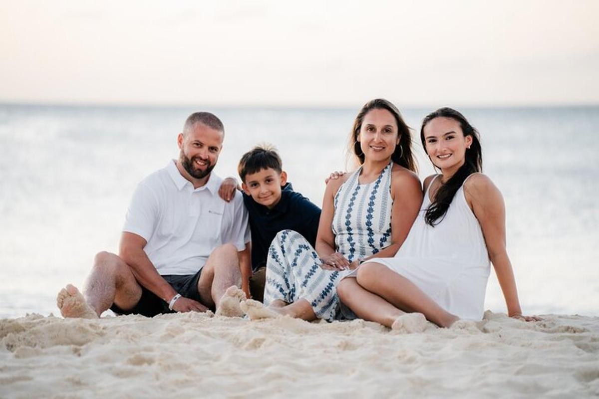 a family sitting in the sand on the beach