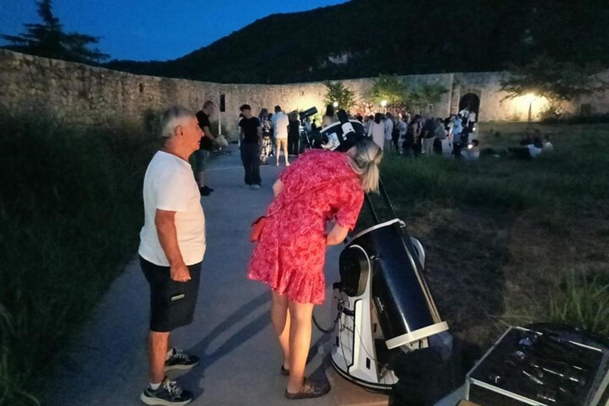 a man and a woman standing next to a scooter