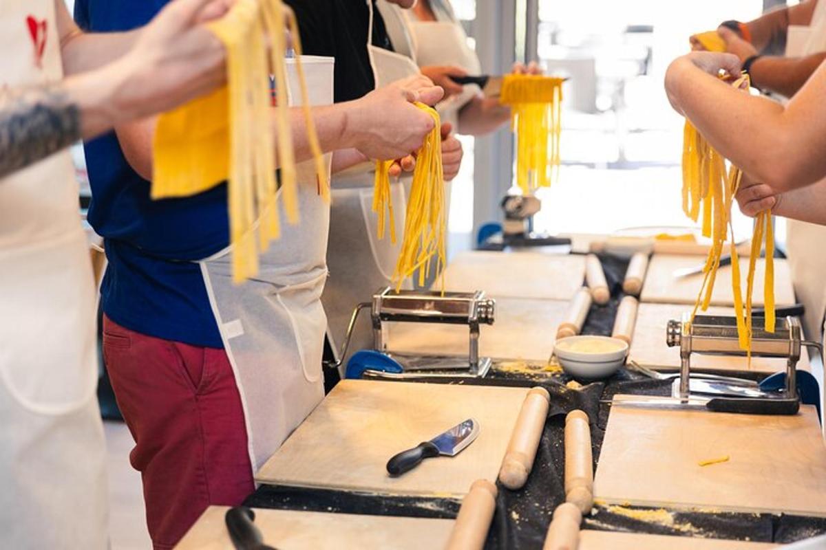 a group of people in a kitchen preparing noodles
