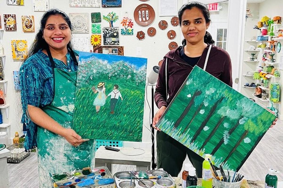 two women are holding a painting in a shop