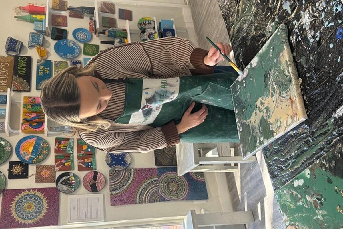 a woman is painting a painting on a canvas
