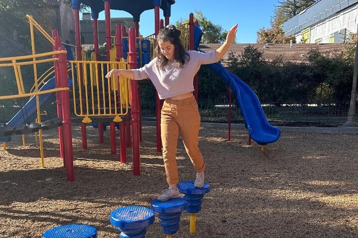 a woman standing on a slide at a playground