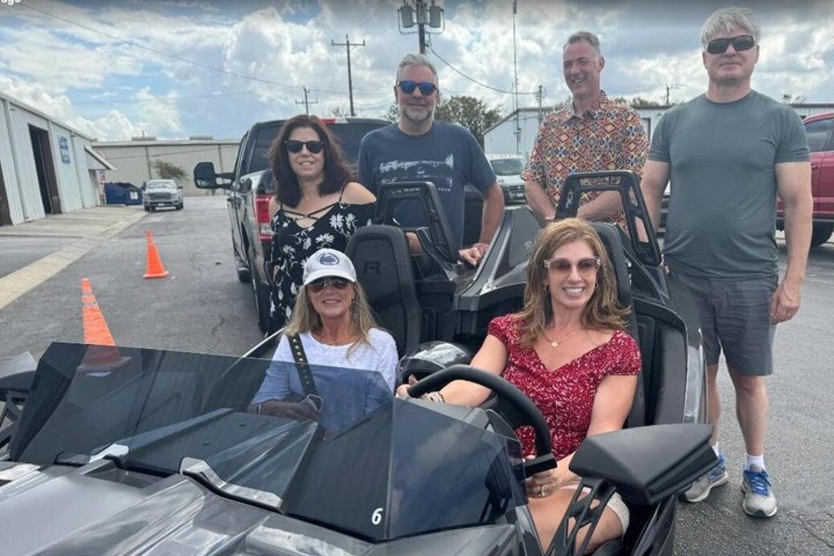 a group of people standing next to a stroller