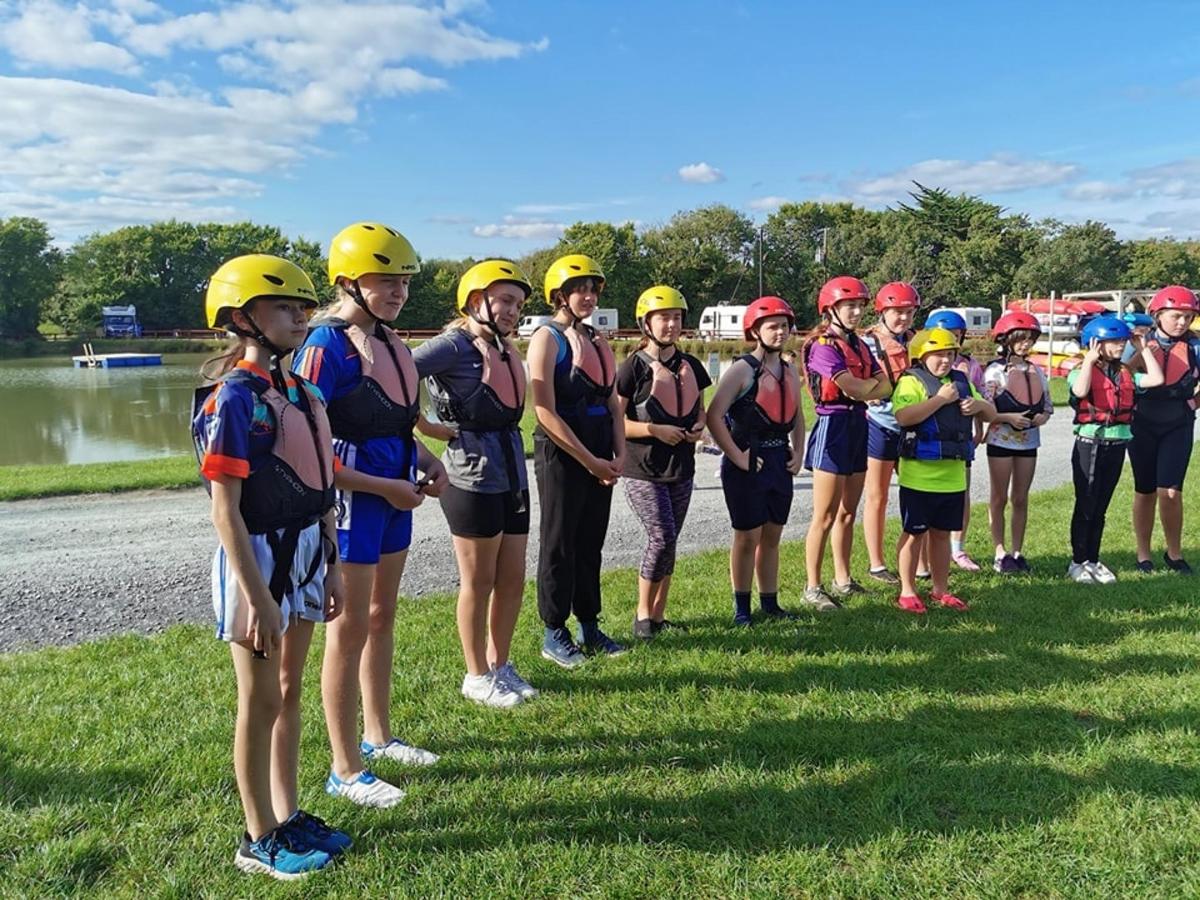 a group of young girls in helmets stand in a line