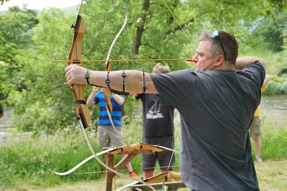 a man holding a bow and arrow in a field