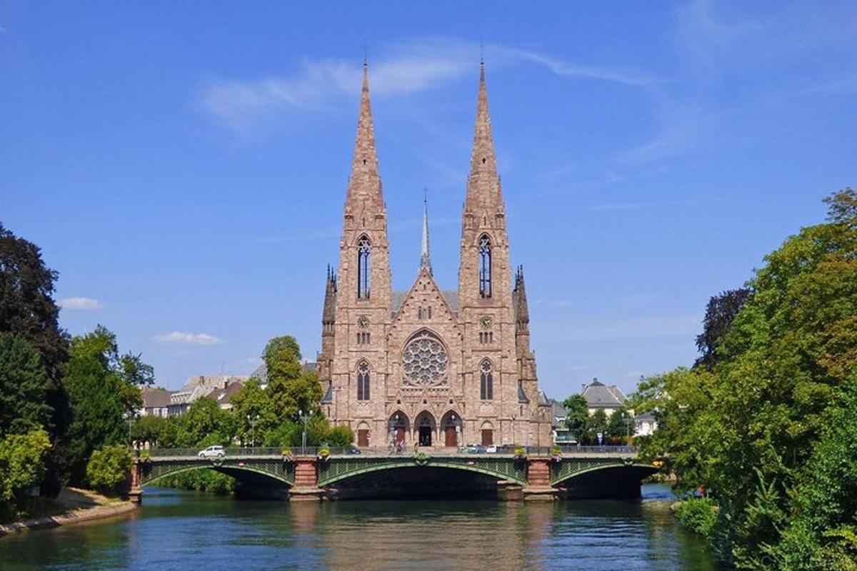 a bridge over a river in front of a church