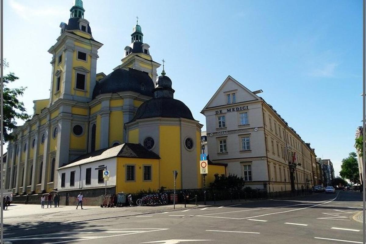 a large yellow building with two towers on a street