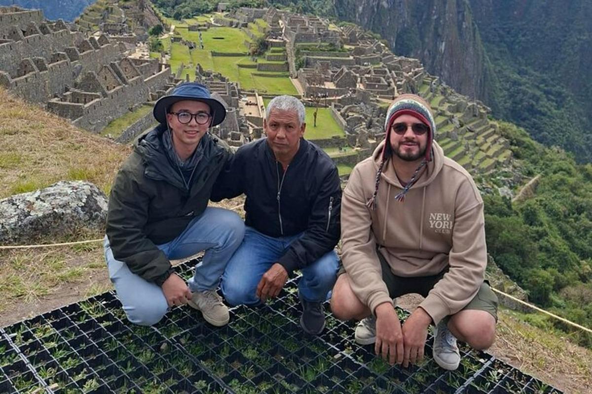 Drei Männer sitzen am Rand einer Pyramide in den Inka-Ruinen.