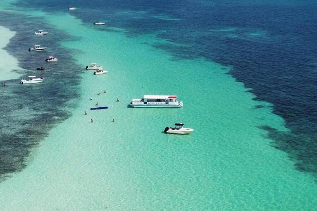 an aerial view of a beach with boats in the water