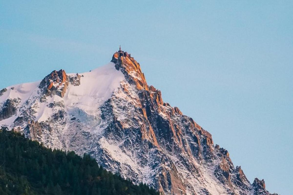 a snow covered mountain with a person on top of it