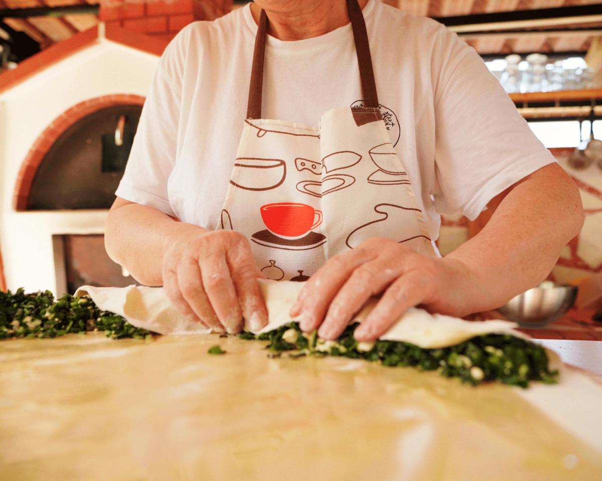 a man in a kitchen preparing food on a cutting board