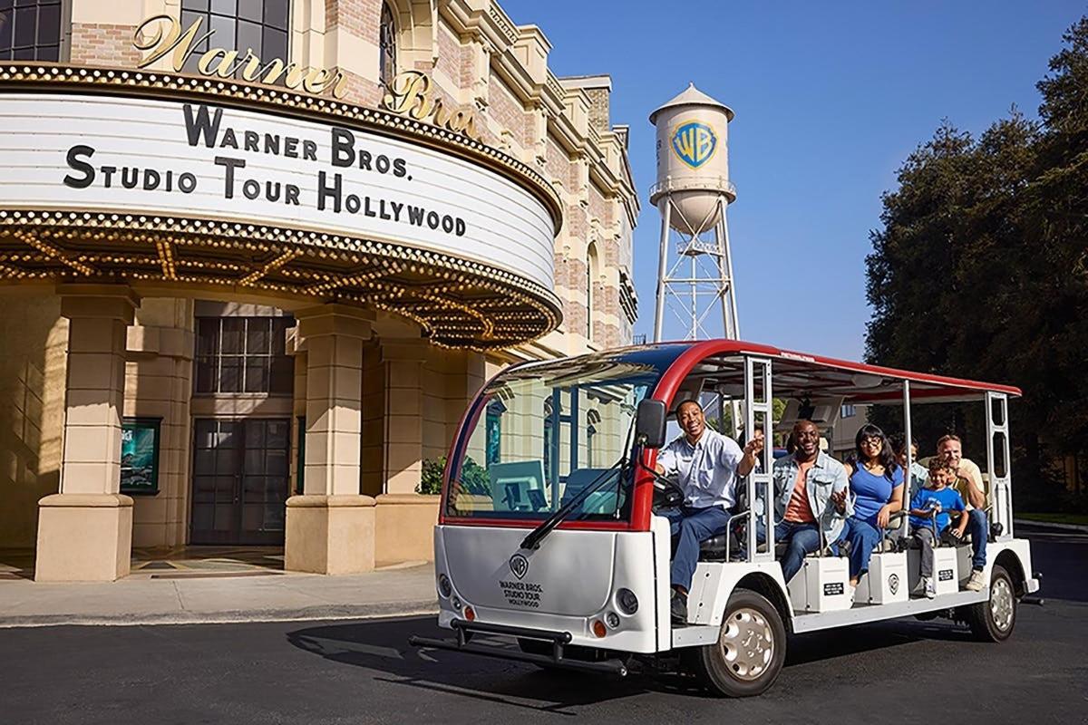 a group of people riding on a golf cart in front of a building